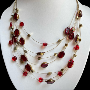 Floating red glass bead necklace on layered goldtone wire with seven strands